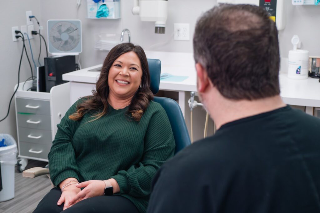 Dr. Benjamin Vela laughing with a happy patient during a consultation at Vela Dental Corpus Christi